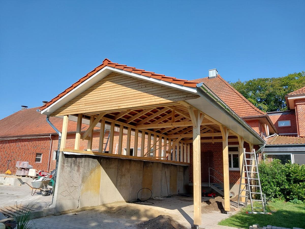 Backsteinhaus mit gealtertem roten Ziegeldach und sichtbarem Moosbewuchs vor der Sanierung.