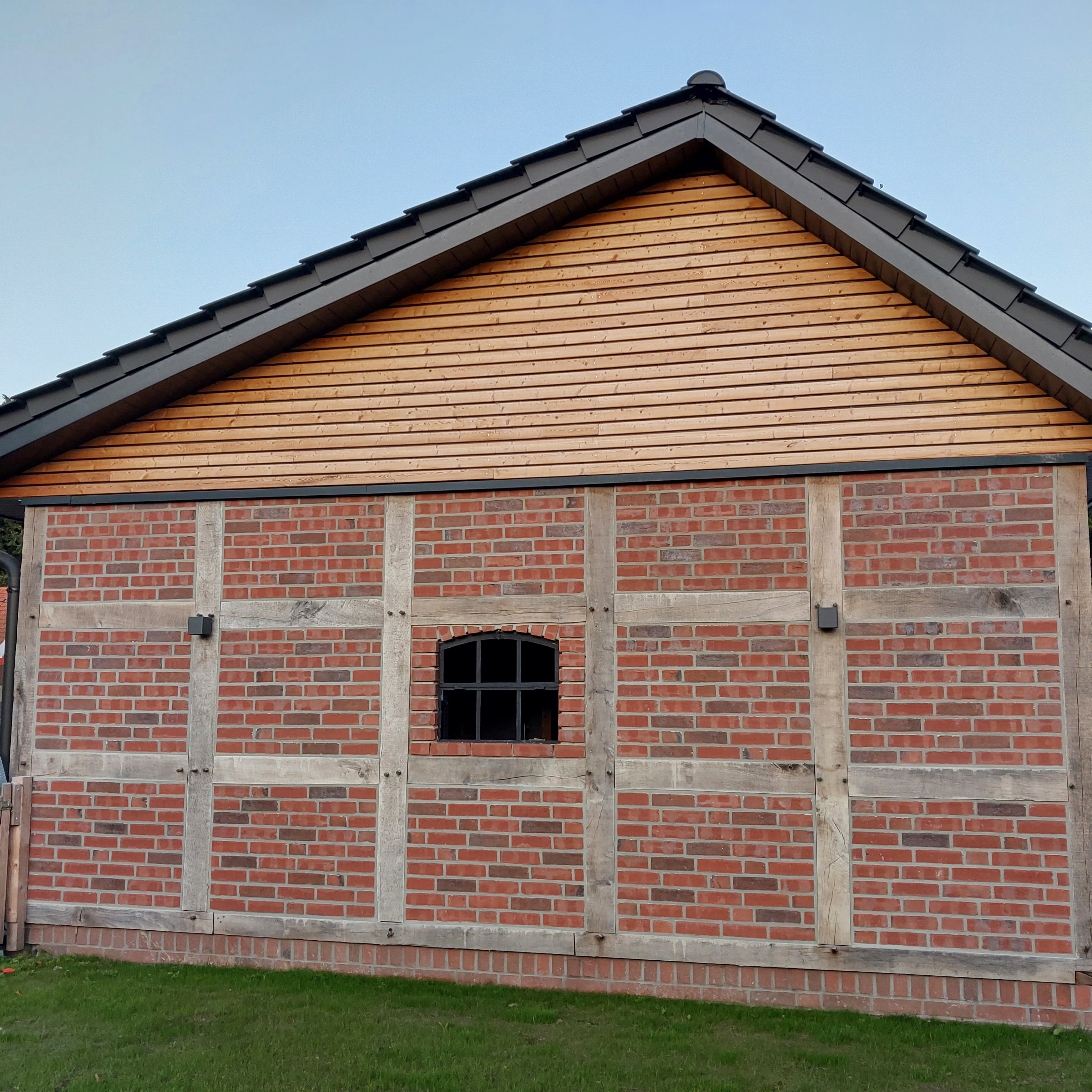 Fachwerk-Carport mit Eichenständerwerk, Kohlebrand-Klinker und Giebelverkleidung aus sibirischer Lärche