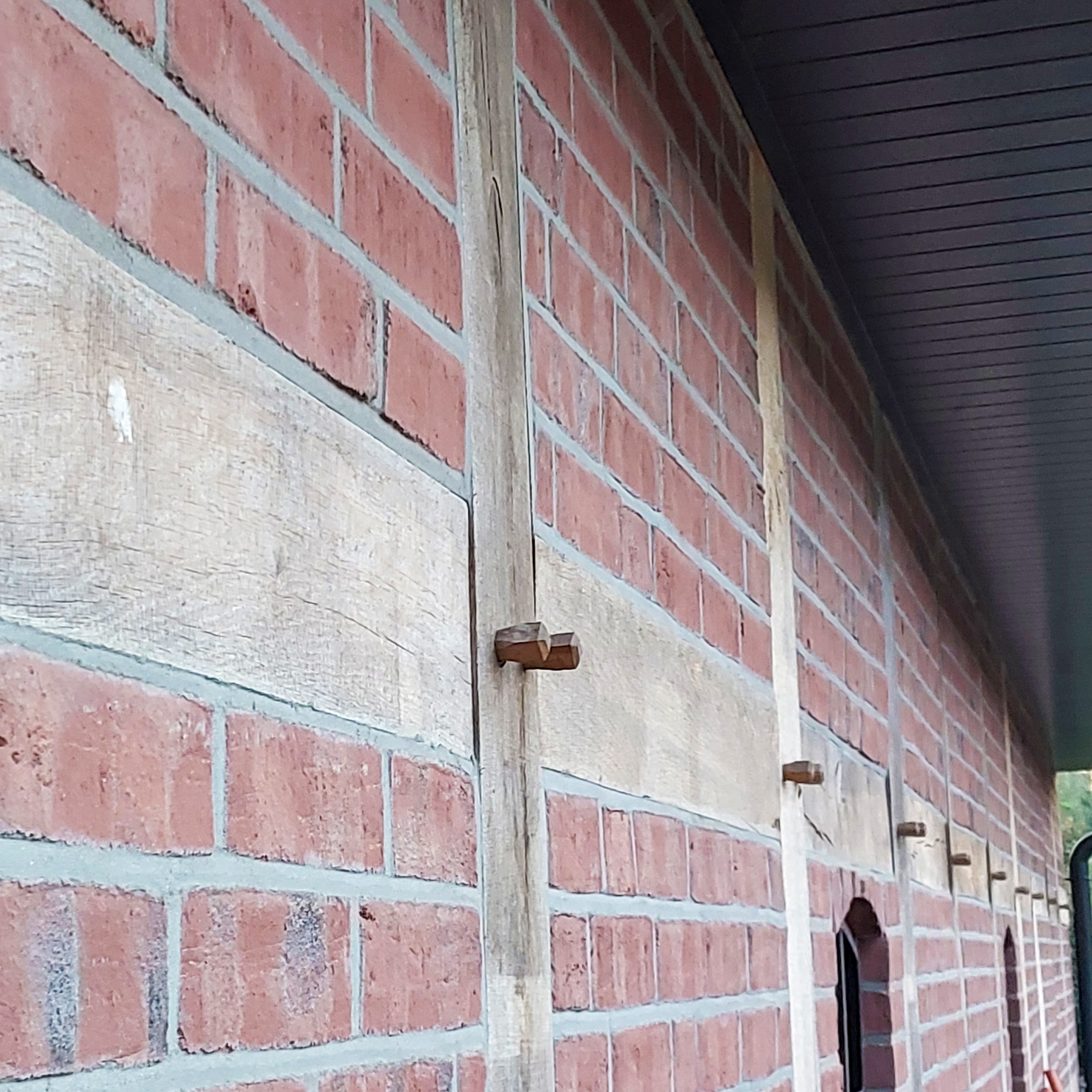 Detailaufnahme der Fachwerkwand mit sichtbaren Holzdübeln und Ziegelmauerwerk