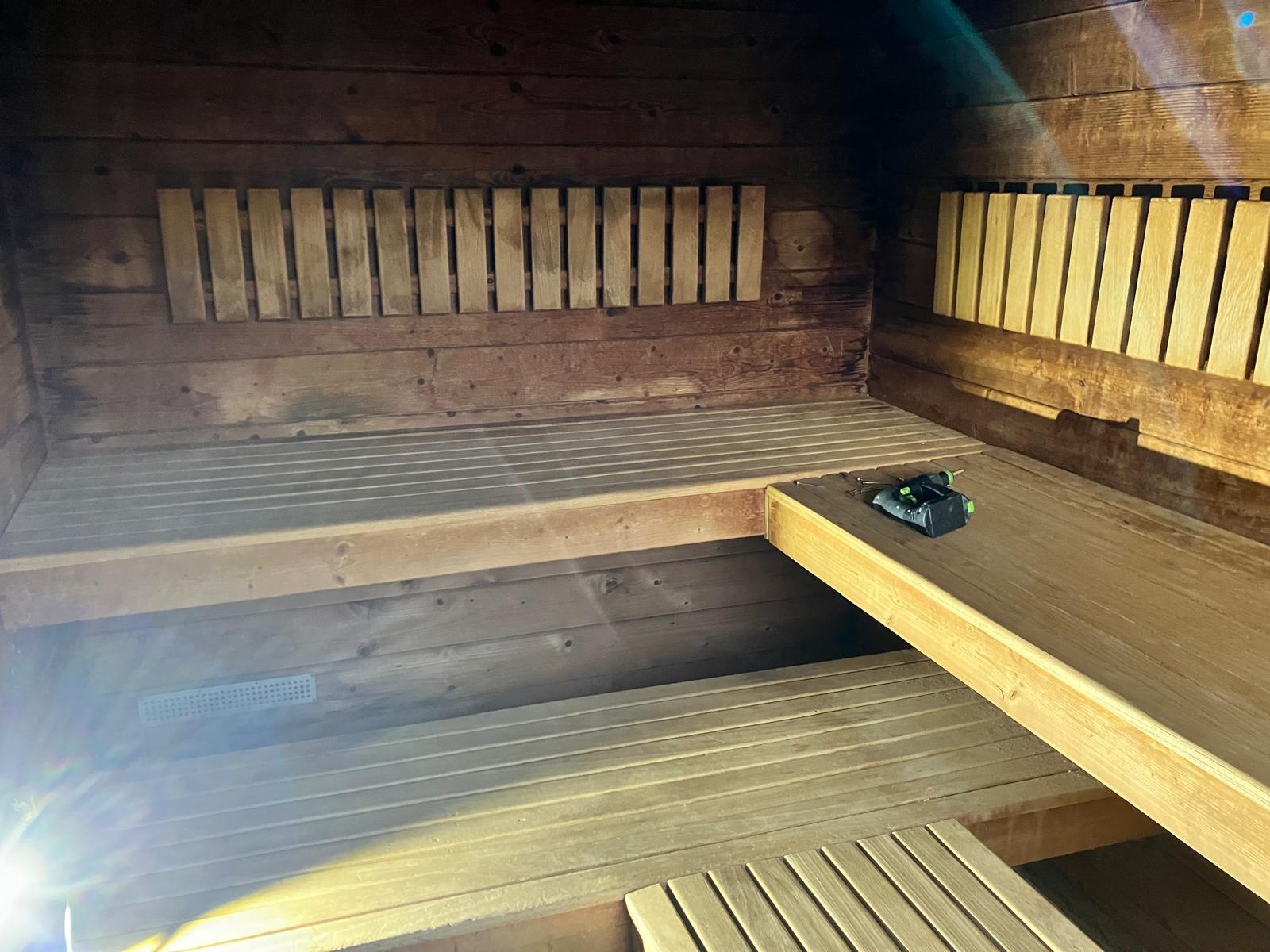Sauna vorher: stark nachgedunkeltes Holz, ältere Bänke und Rückenlehnen